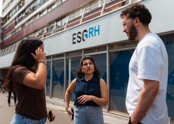 Trois étudiants devant une école